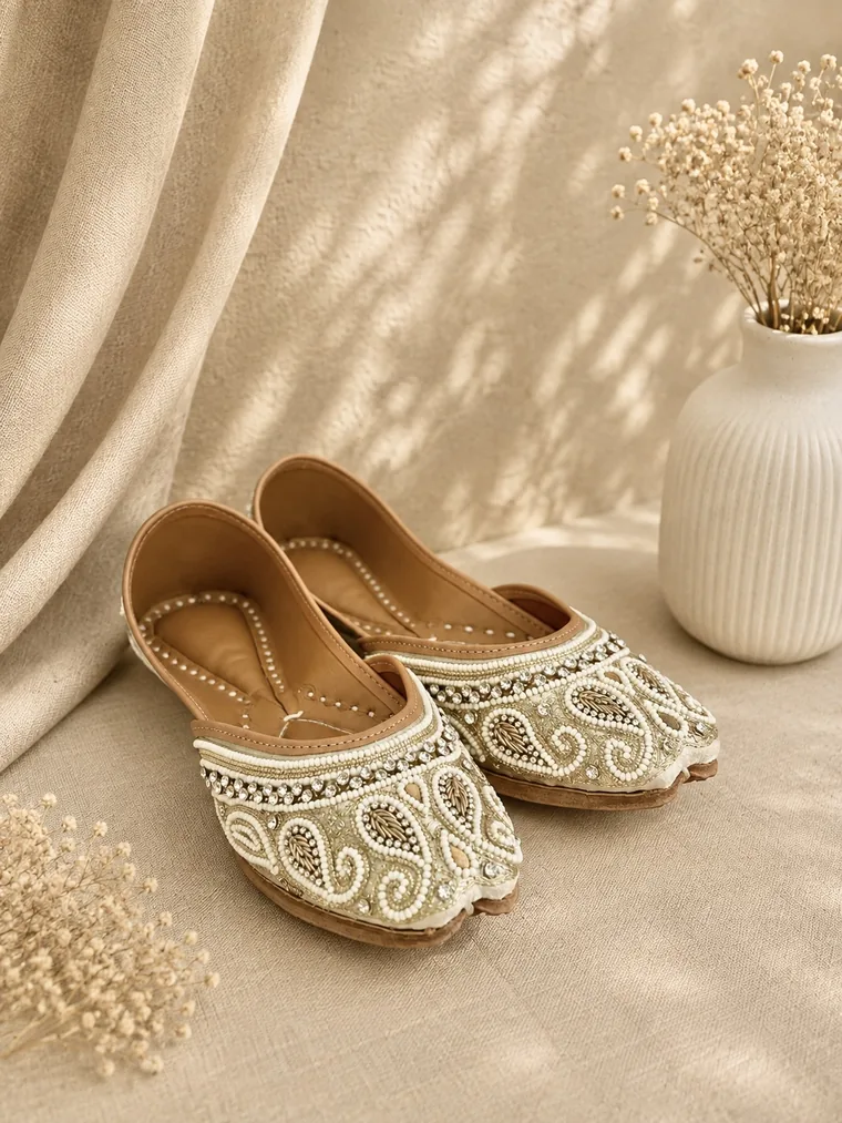 Overhead view of a pair of Ivory Grace juttis showing the smooth cushioned leather insoles.