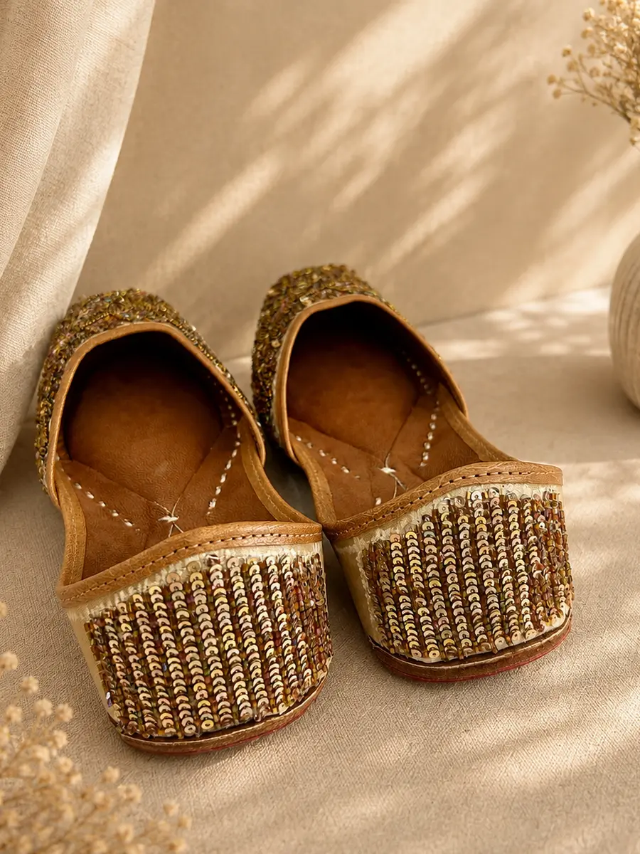 Gold Grace juttis seen from behind, the gold sequin beadwork visible across the heel.