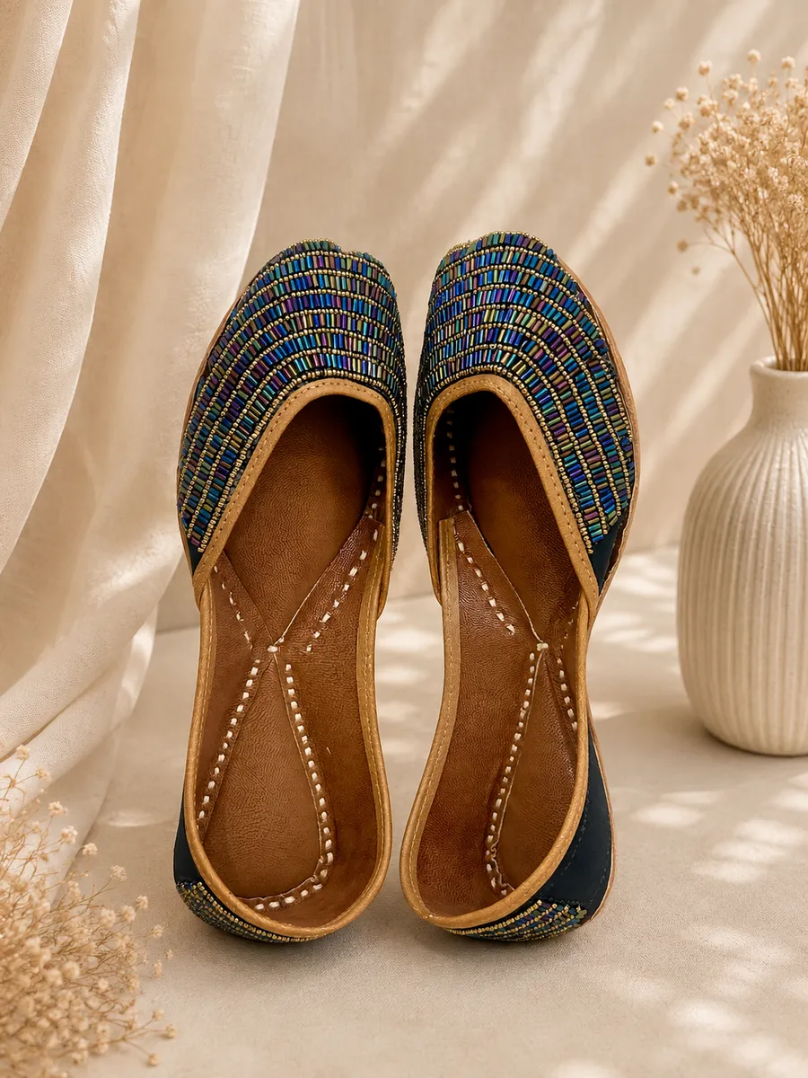 Neel Noor juttis in deep teal-blue with iridescent bead and sequin embroidery in gold-tone rows.